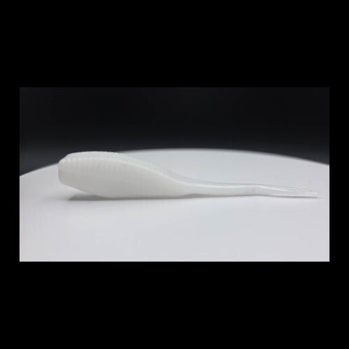 White fishing lure on a white surface with a black background