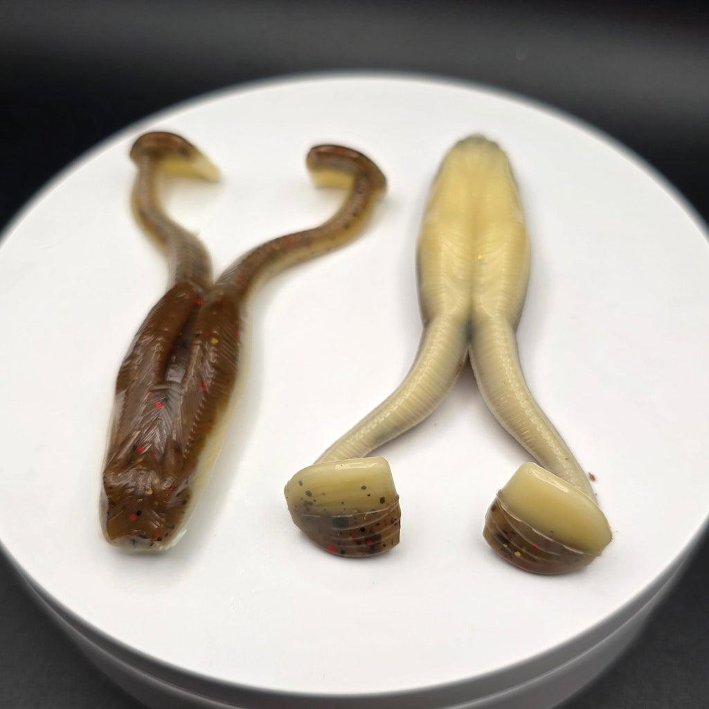 Muddy Water Color and Bone colored fishing lures with glitter on a white circular base against a dark background