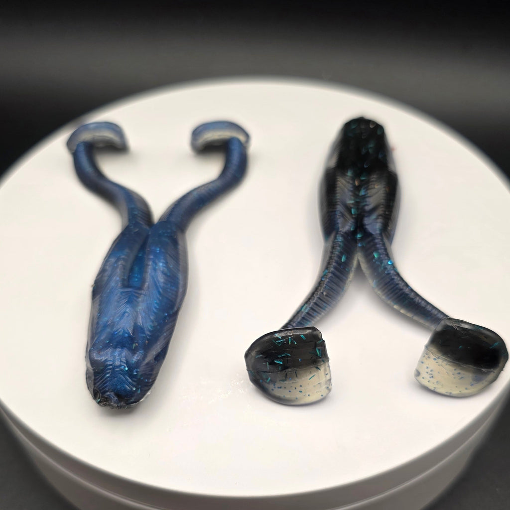 Black and Blue fishing lures with blue glitter on a white circular base against a dark background