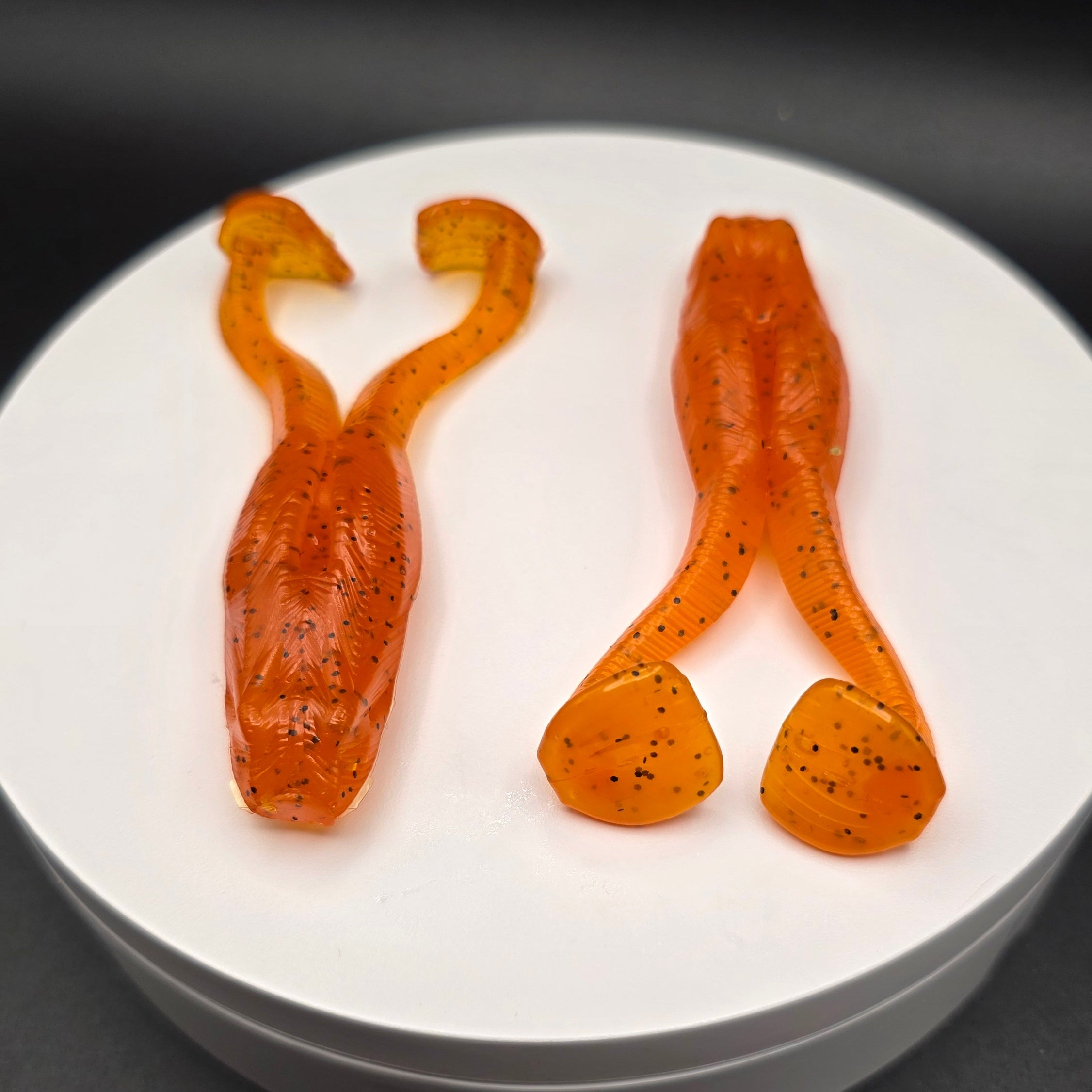 Orange Fishing Lure on white round surface with black background